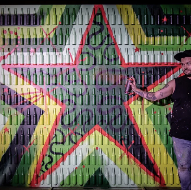 Artist painting a Heineken bottle installation at the same event