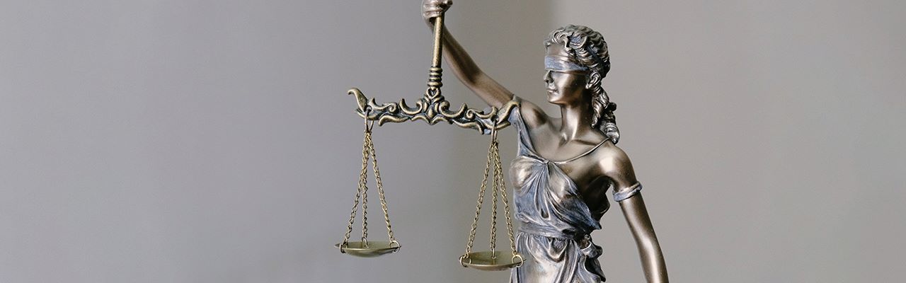metal statue holding scales alluding to justice