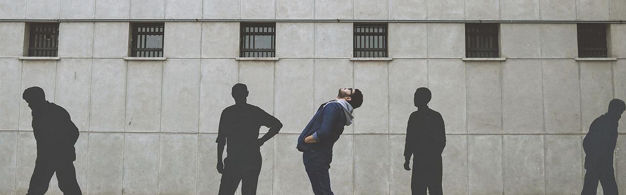 person and shadows in front of a wall