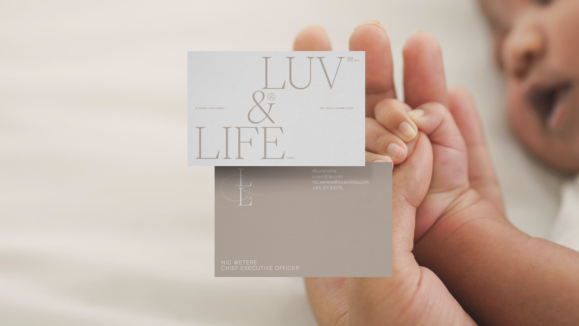 A newborn baby with luv and life buiness cards
